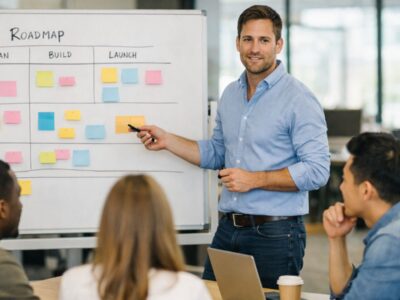 Product manager collaborating with engineering and design team on AI-assisted roadmap in open-plan office